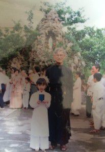Thầy Giuse Võ Văn Tuệ chụp với một em thiếu nhi trong ngày Rước Lễ lần đầu. Ảnh chụp trước hang đá Đức Mẹ, nhà thờ Thái Hà.