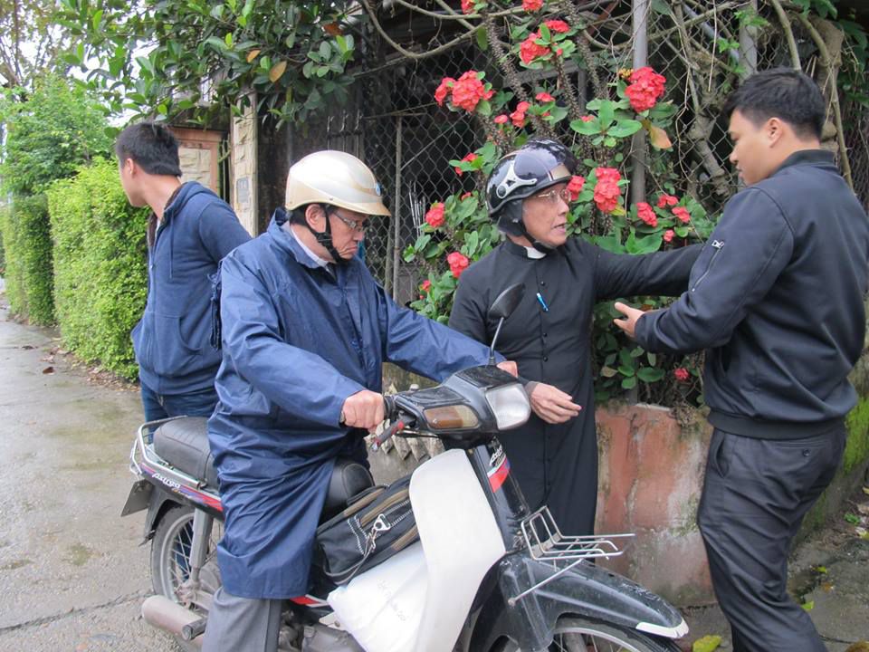 Lm. Trần Văn Quý và Phan Văn Lợi bị hai viên an ninh ngăn cản không cho tới địa điểm dâng lễ. Ảnh FB Phan Văn Lợi