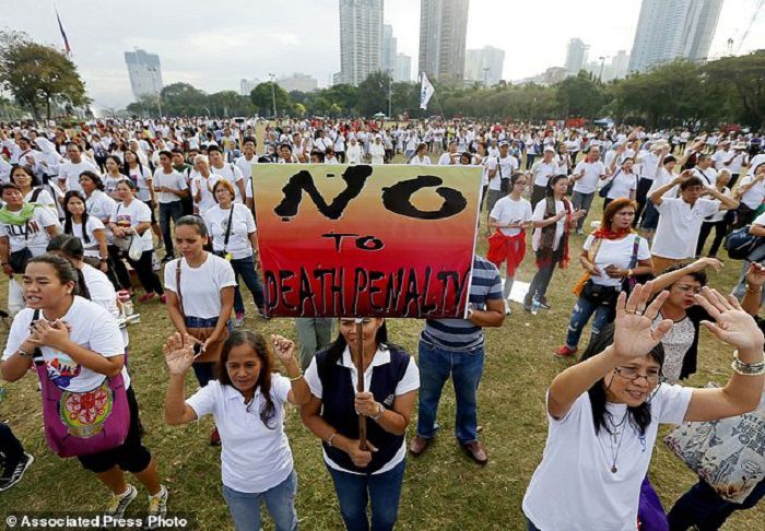 Thousands of Roman Catholics sing religious songs following a "Walk for Life" march around Manila's Rizal Park to oppose the revival of the death penalty by the Philippine Congress as well as the killings of drug users and drug pushers in the so-called war on drugs by President Rodrigo Duterte at dawn Saturday, Feb. 18, 2017 in Manila, Philippines. The Catholic Church expressed alarm over the killings of more than 7,000 people so far since President Duterte assumed office June 30 of last year. (AP Photo/Bullit Marquez)