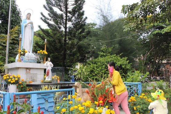 Một phụ nữ dâng hương trước tượng Đức Mẹ trong bệnh viện Bệnh Nhiệt đới ở Sài Gòn. Ảnh: ucanews.com