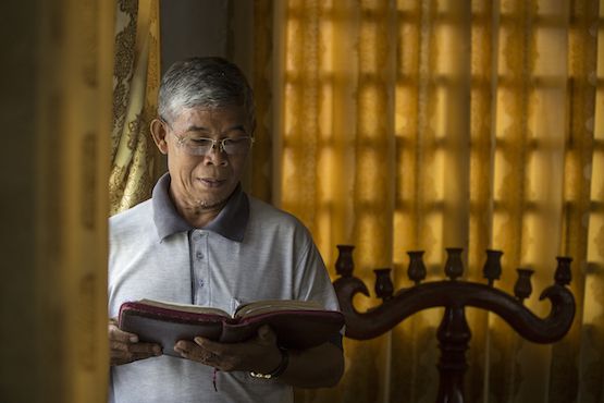 Mục sư Sok Sophon đọc Kinh thánh giữa phòng họp của Hội Truyền giáo Phúc âm liên hiệp của Campuchia ở ngoại ô Phnôm Pênh (Ảnh: Enric Catala Contreras)