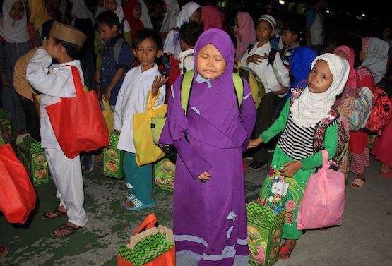 Các trẻ em Hồi giáo nhận quà từ các tình nguyện viên Công giáo sau bữa ăn sáng Eid al-Fitr tại Trường Tiểu học St Maria ở Jakarta, ngày 19 tháng 6 năm 2017 (ảnh ucanews.com)